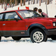 A photo of a red AMC Eagle parked on snow.